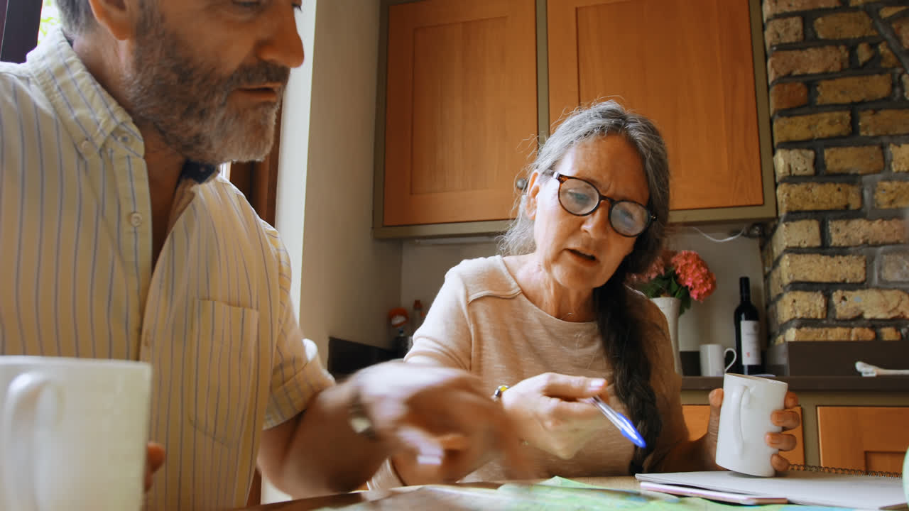 pareja de ancianos calculando facturas en casa 4k