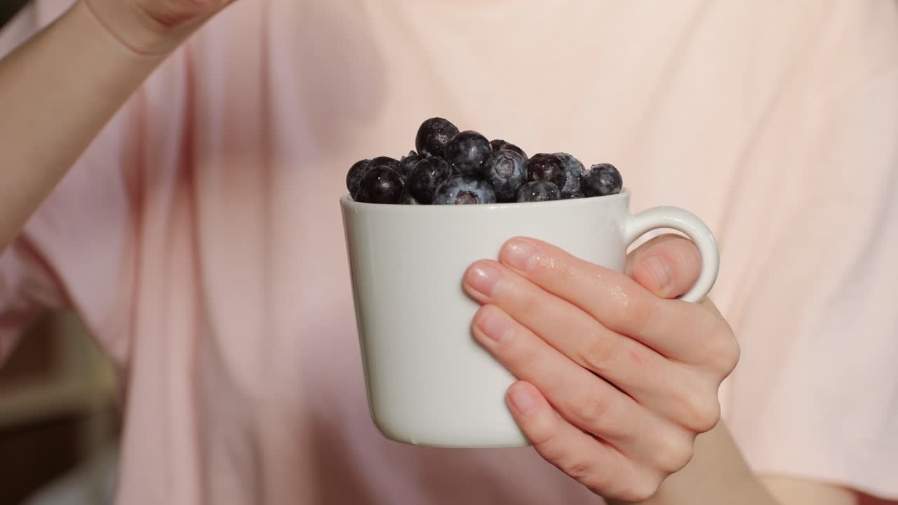 Woman holding a cup of blueberries