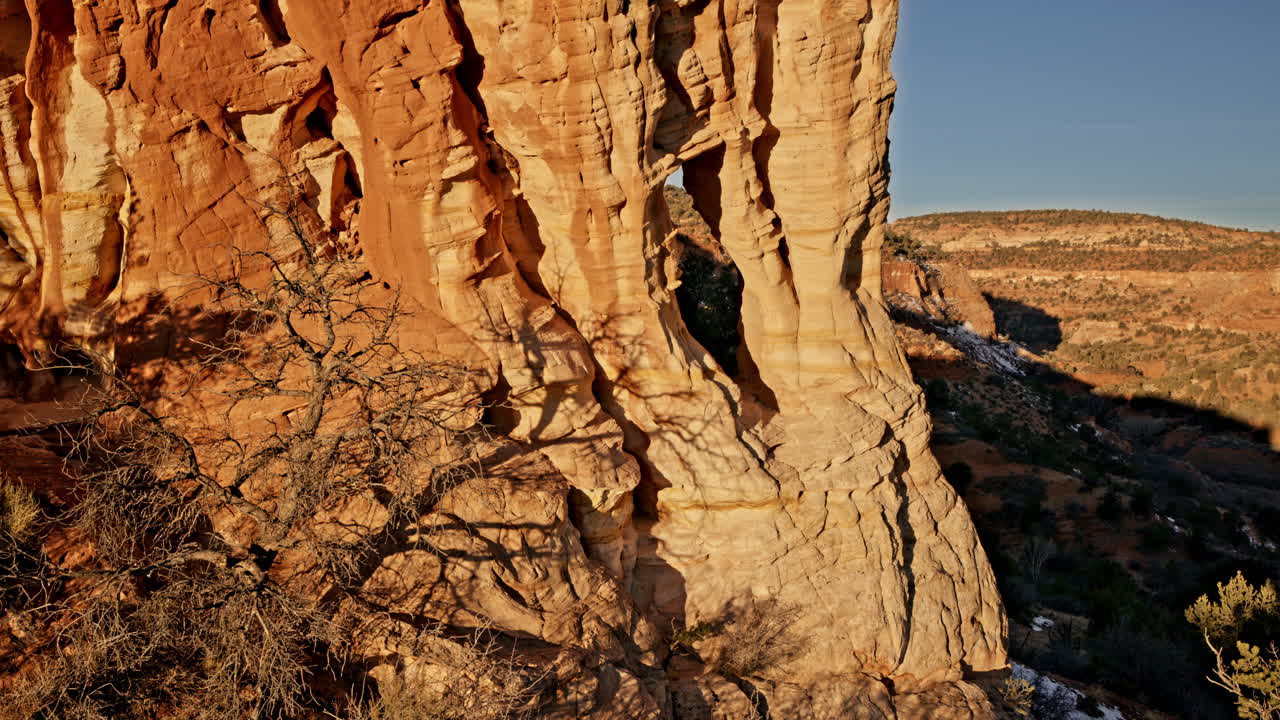 Aerial perspective of a secluded desert arch glowing in the early morning light near Kanab, Utah.