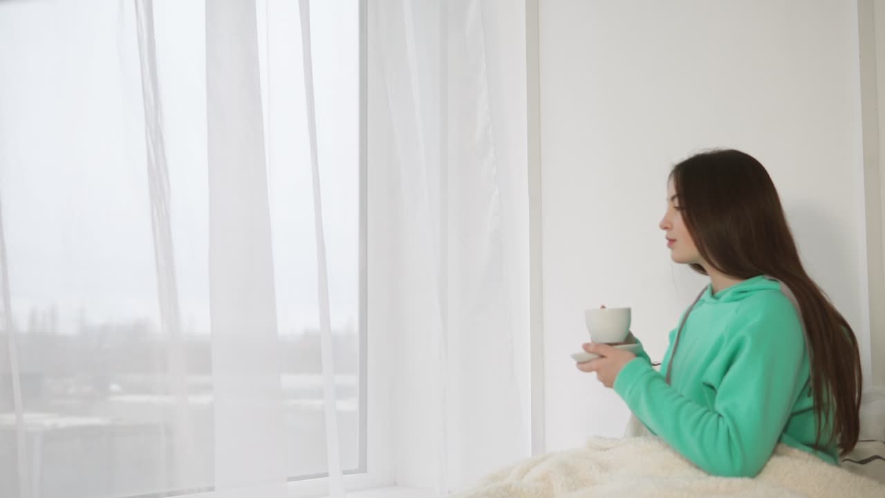 창문 에서 커피를 마시는 여자