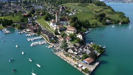 aerial view with a drone of the castle in spiez and the port with thun lake in canton of bern in switzerland