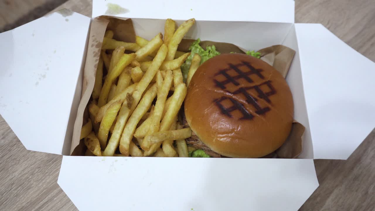 el trago de hamburguesa con papas fritas en la caja de papel.