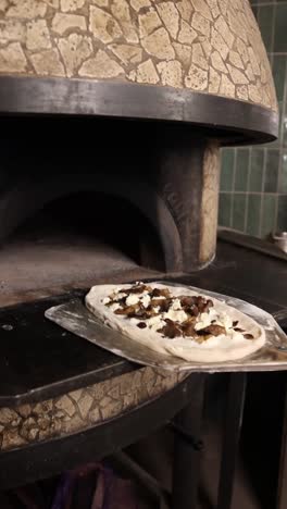 pizza being cooked in a wood-fired oven