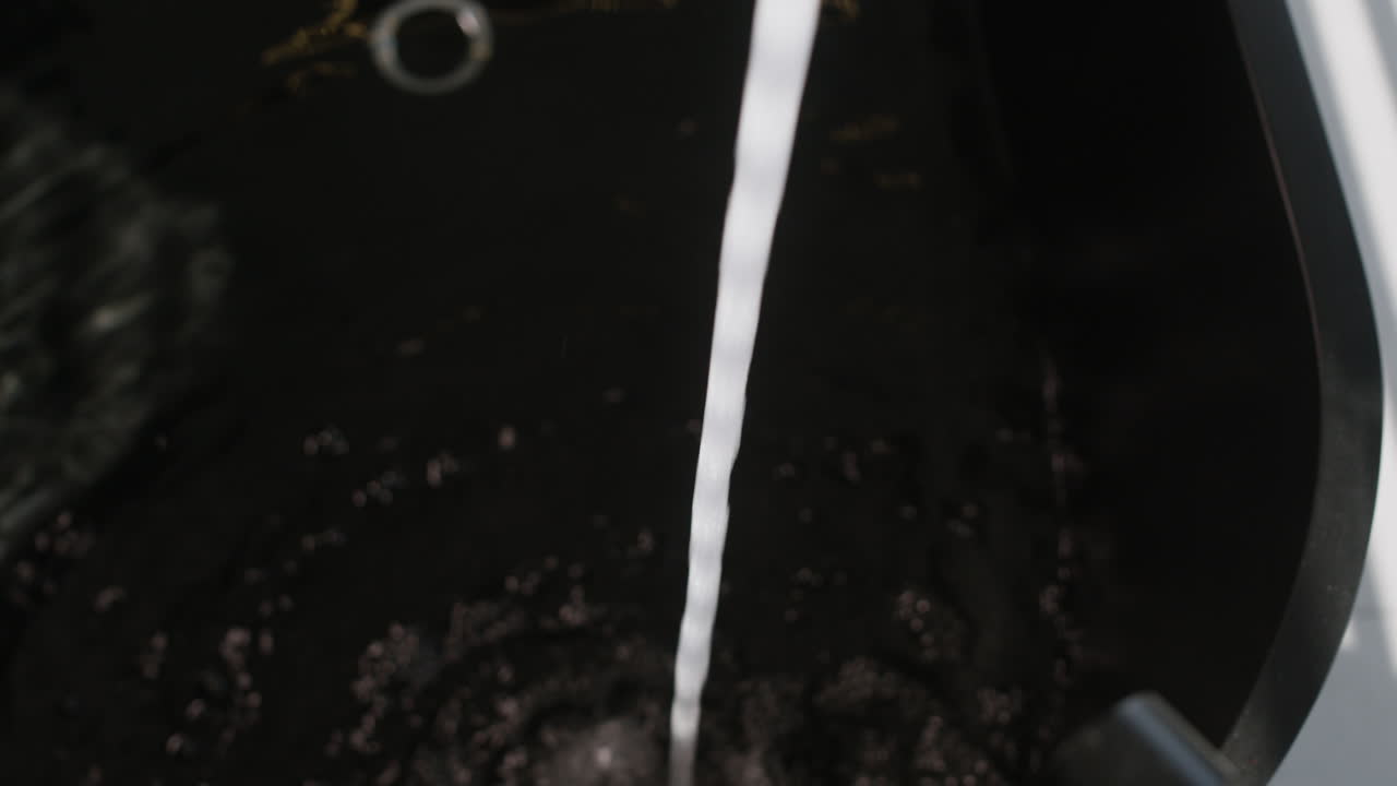 Water pouring into a dark sink
