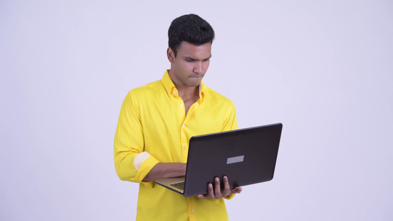 joven feliz y guapo hombre de negocios indio con computadora portátil