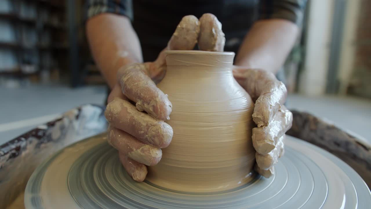 Seamless loop of hand-made ceramic pot spinning on potter's wheel in craftsman's hands
