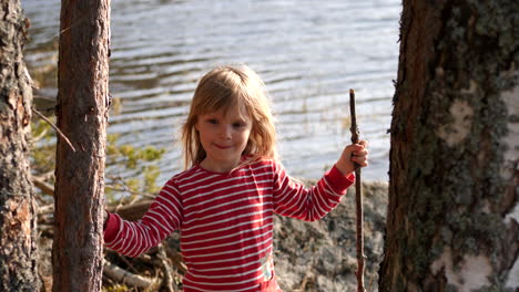 lifestyle portrait of cute shy girl in nature looking at camera, organic slow motion