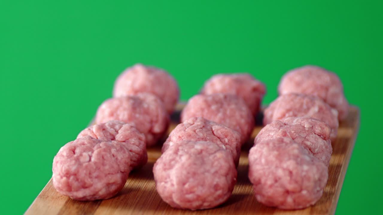 las albóndigas crudas de carne fresca en el tablero giran lentamente.