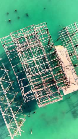 aerial view of the collapsed west pier in brighton with turquoise water