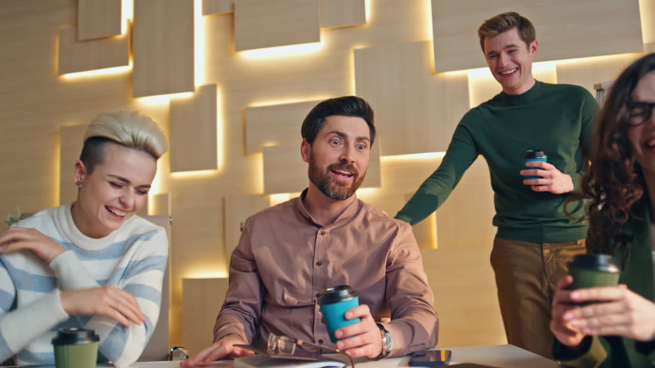 colegas riendo pausa para el café en el espacio de trabajo de cerca. comunicación amistosa