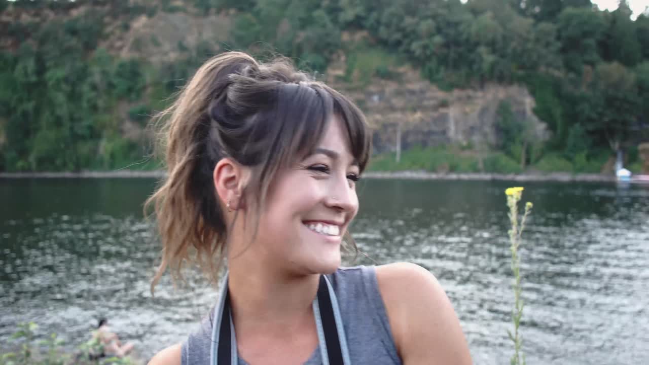 카메라를 들고 진정으로 웃고 있는 귀여운 힙스터 소녀의 핸드헬드 초상화