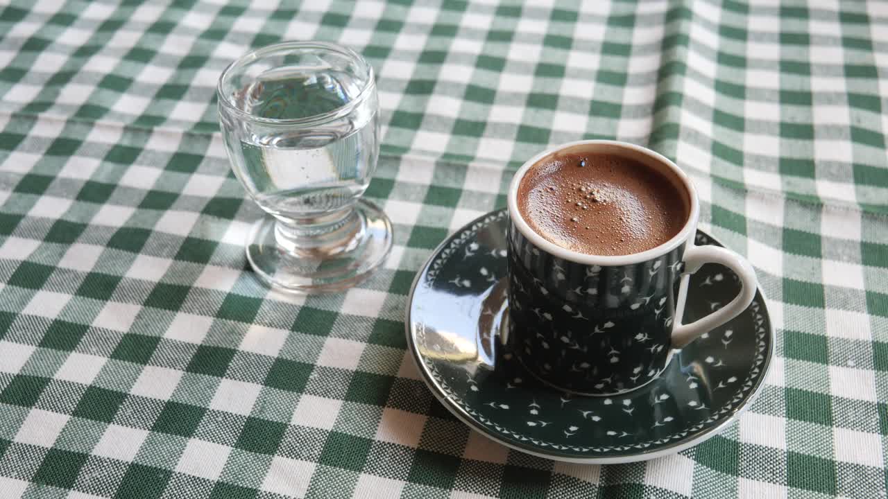 Turkish Coffee with a Glass of Water on a Green Checkered Tablecloth