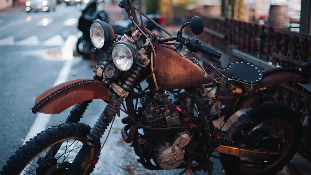 Close up of a vintage rusty motorcycle parked on a city street