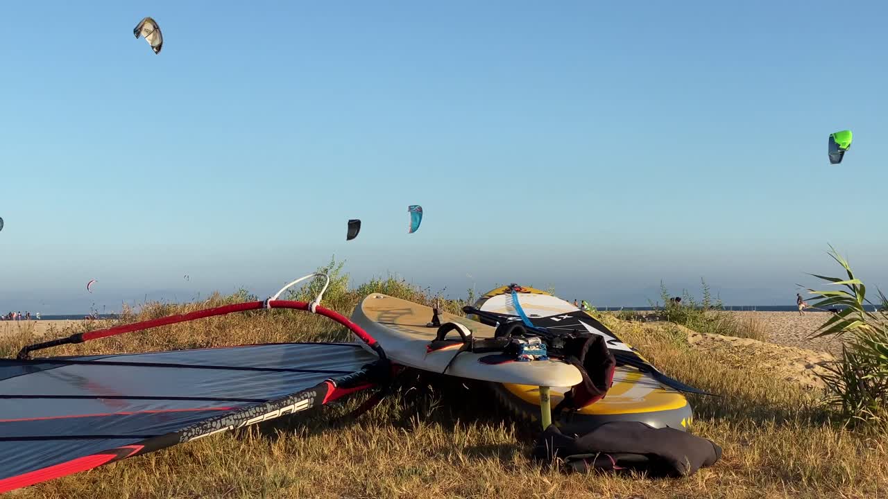 Slow pan to the left of surfing boards in the sand of the beach of Tarifa.