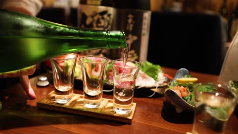 sequence of sake being poured into glasses