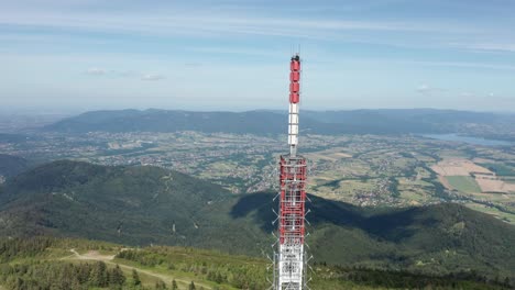 toma de órbita aérea del transmisor de la torre gsm en la colina skrzyczne con beskid de silesia y el lago żywieckie en el fondo