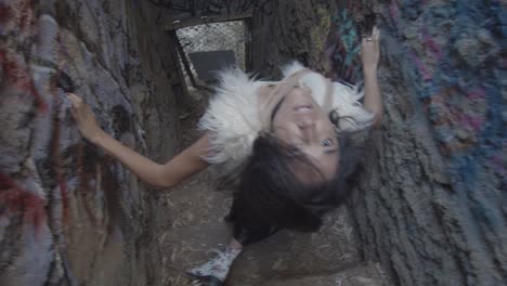 slow motion shot of a strange interpretive dancer who spins around staring straight into a high angle shooting down at her in an abandoned zoo staircase