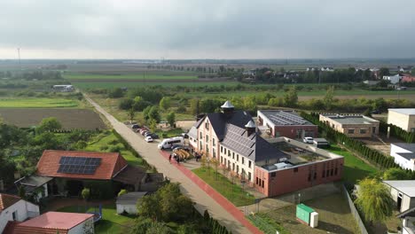 building-with-solar-panel-on-roof-sunny-day-small-town-aerial-circulating