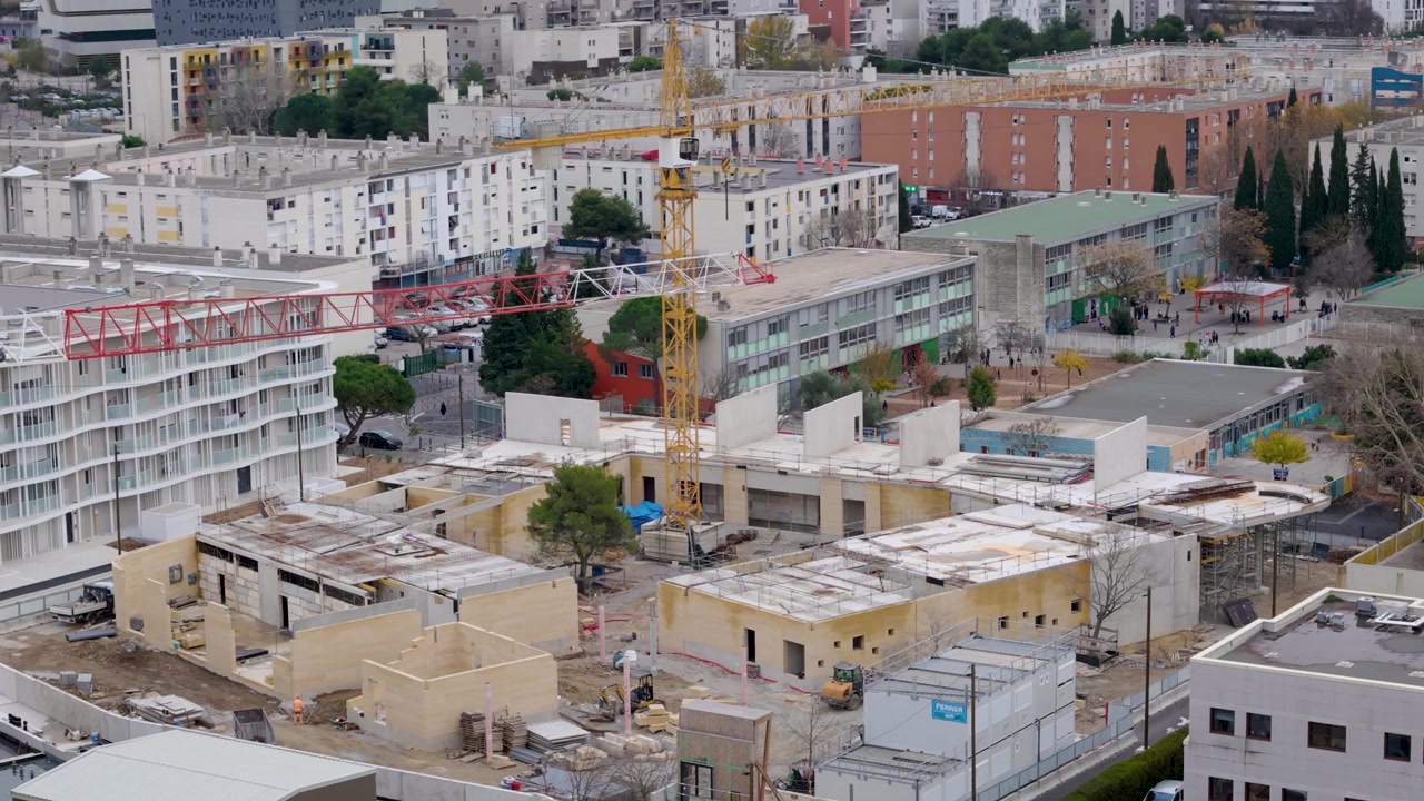 Camera pans right across buildings and a construction site in Montpellier