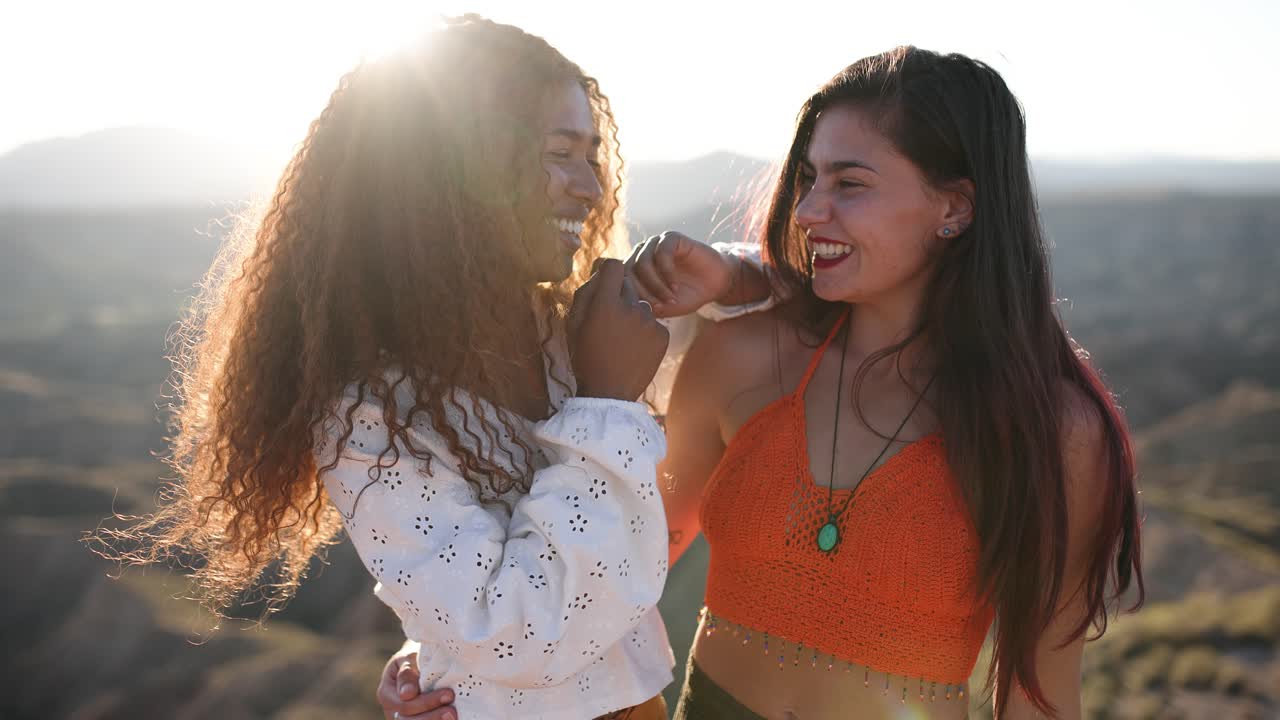 Zwei glückliche Freunde, die im Sonnenlicht der goldenen Stunde zusammen lachen.