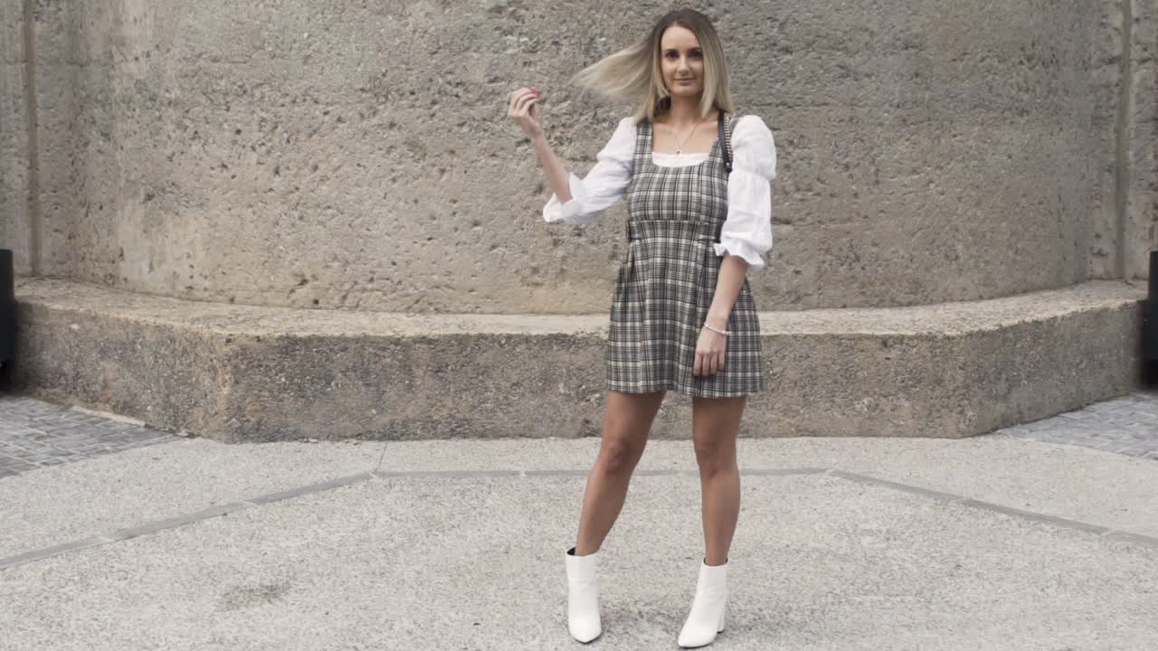 toma amplia de mujeres girando y pasando su mano por su cabello rubio