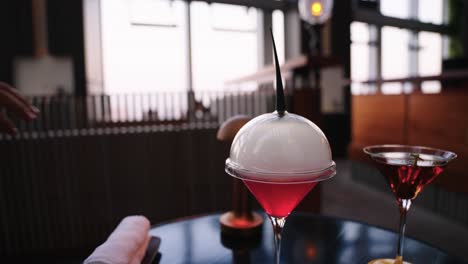 expensive cocktail reveal with bar blurred background