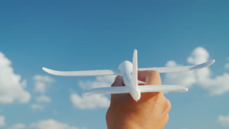 una mano masculina sostiene un avión de juguete dirigido a la idea del cielo y sueña en el concepto de negocio video 4k