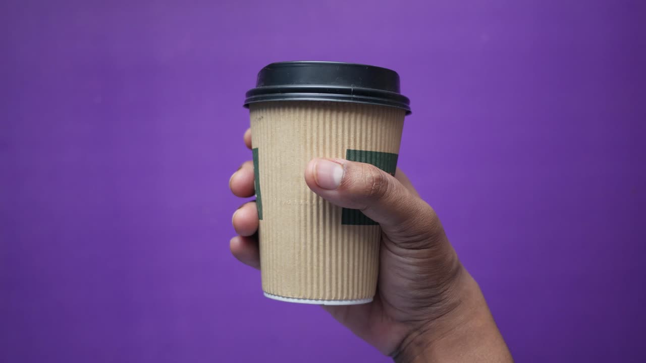 mano con una taza de café desechable