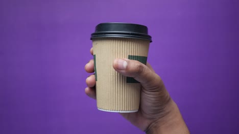 hand holding a disposable coffee cup