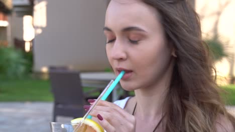 beautiful girl drinks a rainbow cocktail