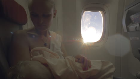 woman nursing baby during the flight view against sun flare