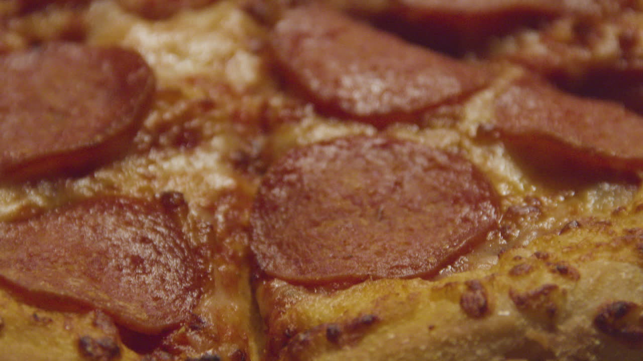 un primerísimo plano de la pizza de pepperoni en la caja de cartón - inclinar hacia abajo