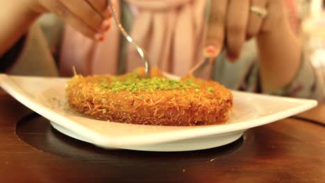 woman eating turkish kunafa dessert