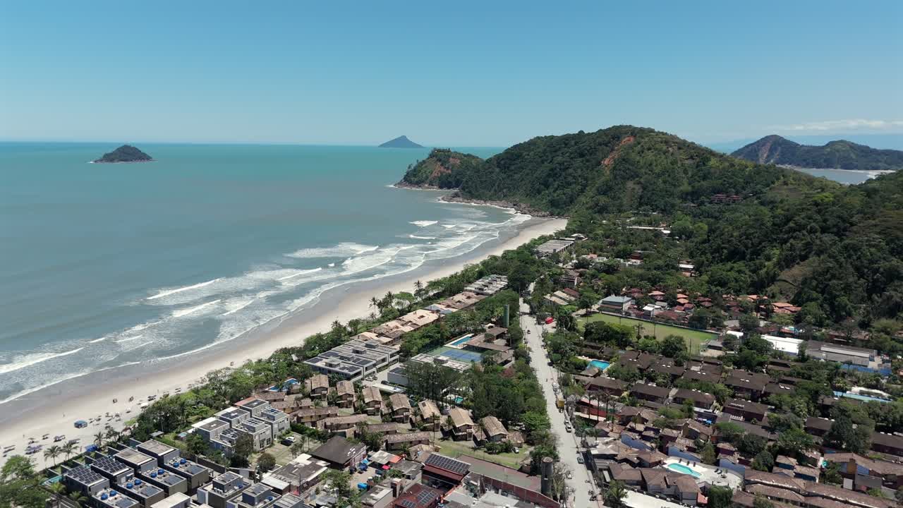 Complesso di case a schiera e condomini sul lungomare a Praia de Camburi a São Sebastião, Brasile. Ripresa aerea con drone