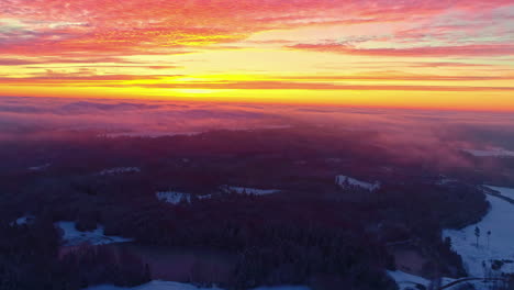 Drone-Volando-Hacia-Un-Mar-De-Nubes-Sobre-Un-Paisaje-Nevado-En-Una-Impresionante-Puesta-De-Sol