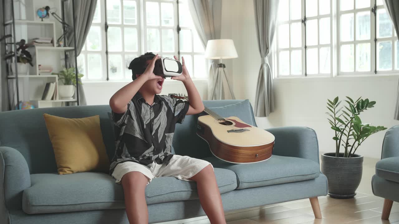 Boy Wearing VR Headset on Couch with Guitar