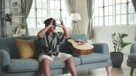 boy wearing vr headset on couch with guitar