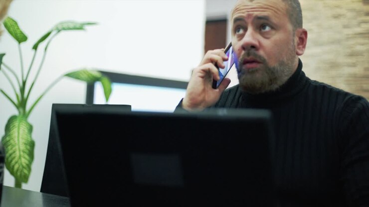 Ein besorgter Mann telefoniert im Wohnzimmer