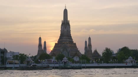 scenery over wat arun temple at dusk, silhouette handheld shot