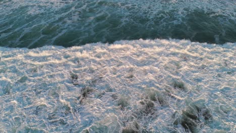 vista aérea de las olas del océano chocando, mostrando el movimiento dinámico del agua