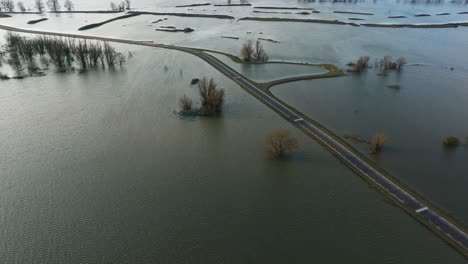 vista aérea de una carretera rodeada de campos inundados a lo largo del río waal en los países bajos después de fuertes lluvias inundaron el norte de europa