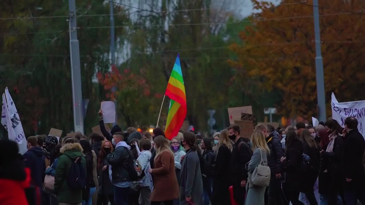 Crowds Of Demonstrators Gathered And Walking In Street With Pace Flag Waving In The Wind During The Widespread Protest Against The Total Ban Of Abortion In Szczecin, Poland. - wide shot