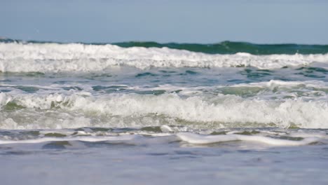 slow motion view of breaking turquoise waves on sylt beach in germany