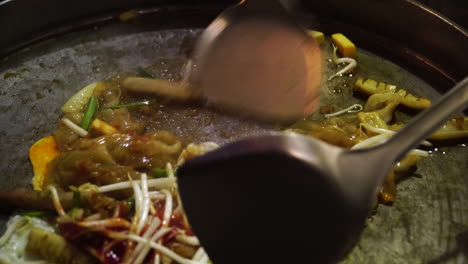 cocina tailandesa y mezclar huevo y fideos en una gran sartén de acero, comida tailandesa local