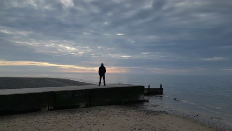 Mann-Stand-Bei-Sonnenuntergang-Am-Stegende-Und-Enthüllte-Die-Küste-Von-Fleetwood-Beach,-Lancashire,-Großbritannien