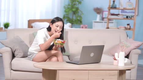 attractive young girls surfing internet or shopping online on a laptop computer sitting on the sofa at home