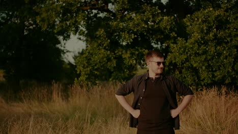 Portrait-Of-Trendy-Man-In-Sunglasses-Looking-Into-Camera-Outdoors