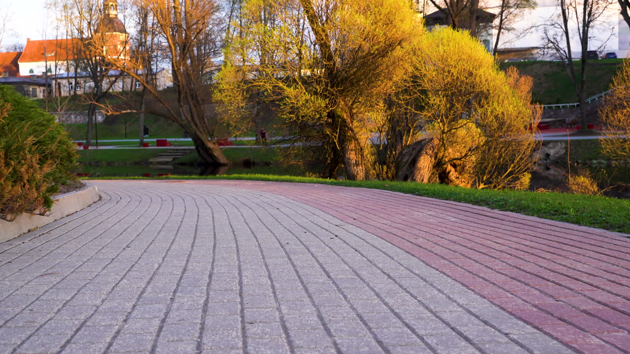 Pathway in Valmiera park during golden hour, Latvia in low angle dolly in footage