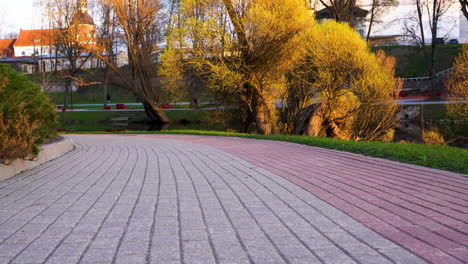 Camino-En-El-Parque-Valmiera-Durante-La-Hora-Dorada,-Letonia-En-Plataforma-Rodante-De-ángulo-Bajo-En-Imágenes