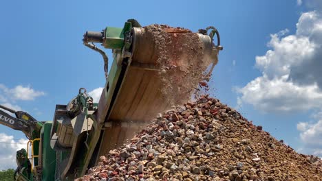 rocas trituradas y hormigón saliendo de la correa de una trituradora de rocas-1